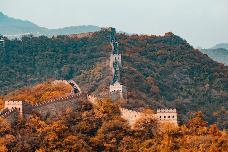 Muralha da China serpenteando por montanhas cobertas de vegetação outonal